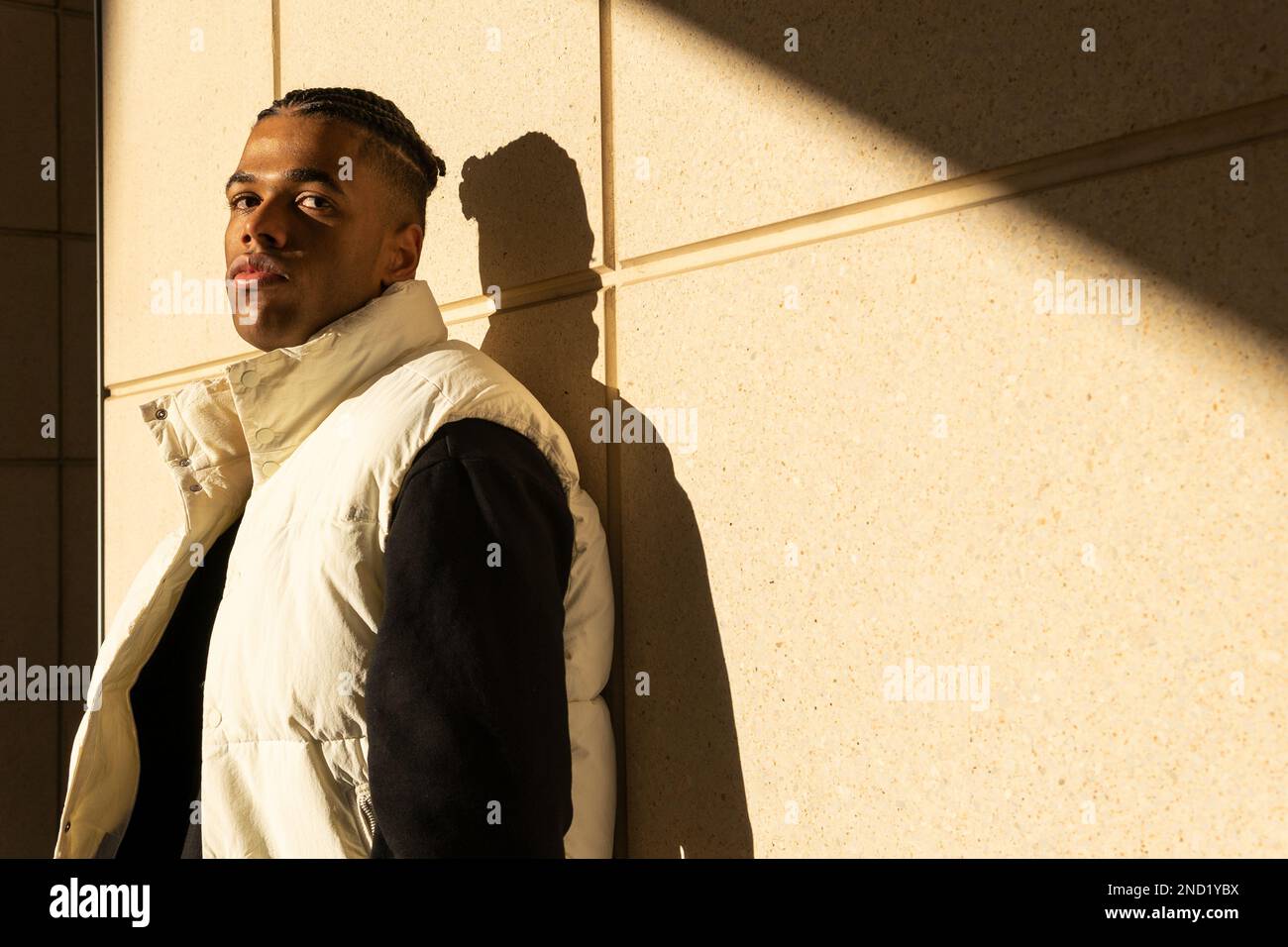 Confident young African American male with braided hair in trendy ...