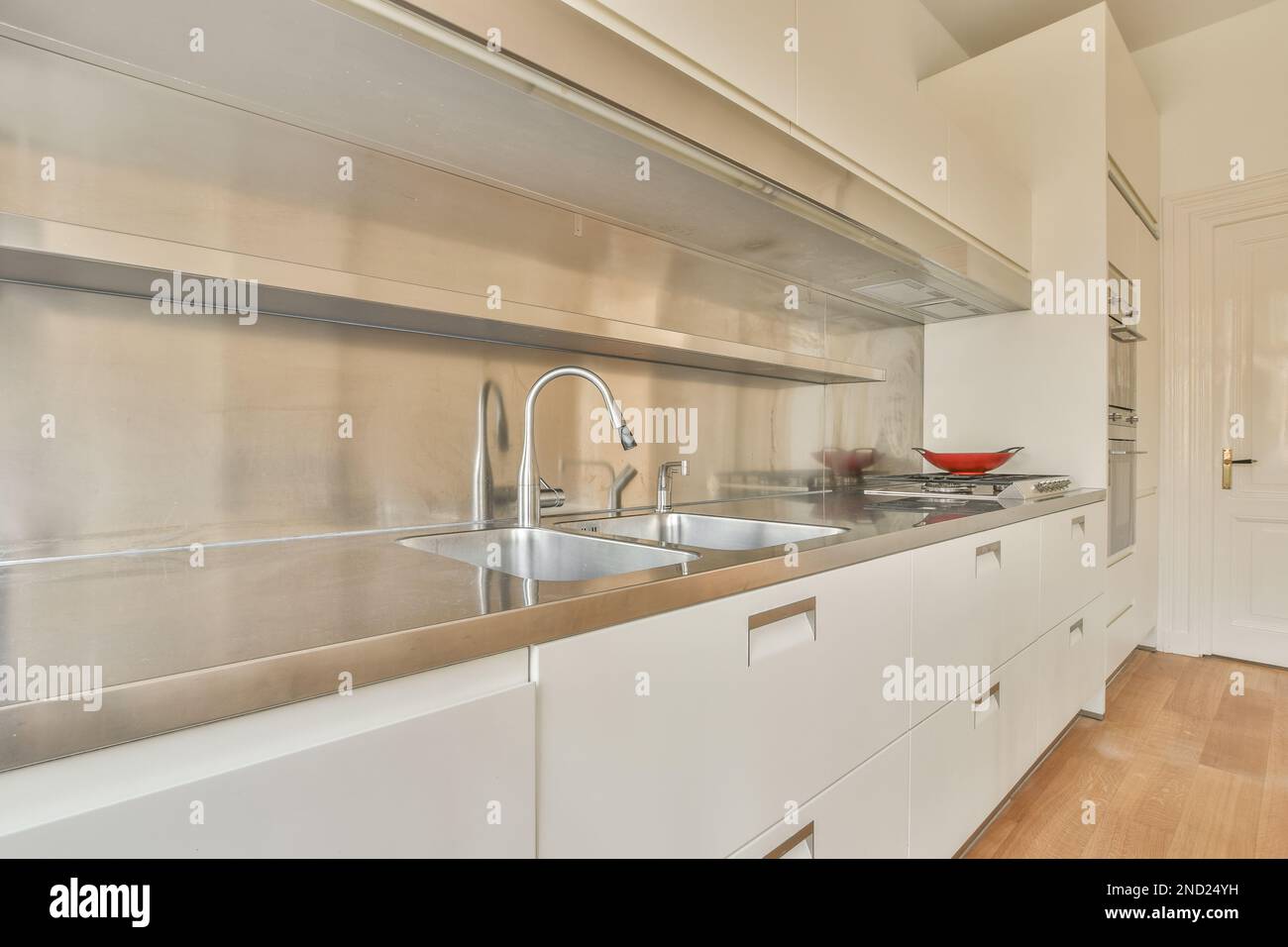 Interior of modern kitchen with white cabinets and built in stove and ...