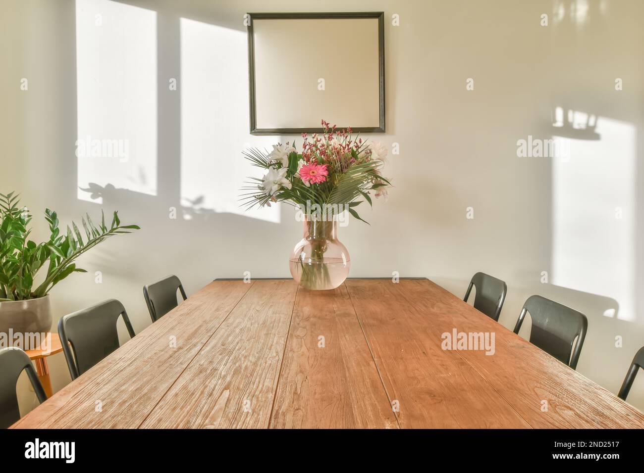 Interior design of dining room with wooden table black chairs potted ...