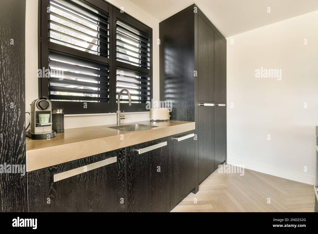 Interior design of kitchen with wooden black cabinets sink window with ...