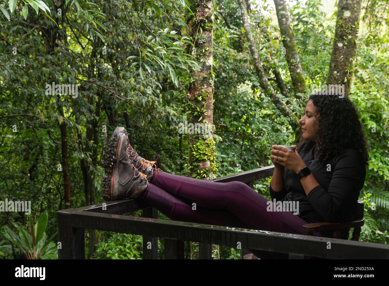 Full body of calm female in casual clothes sitting on wooden chair and