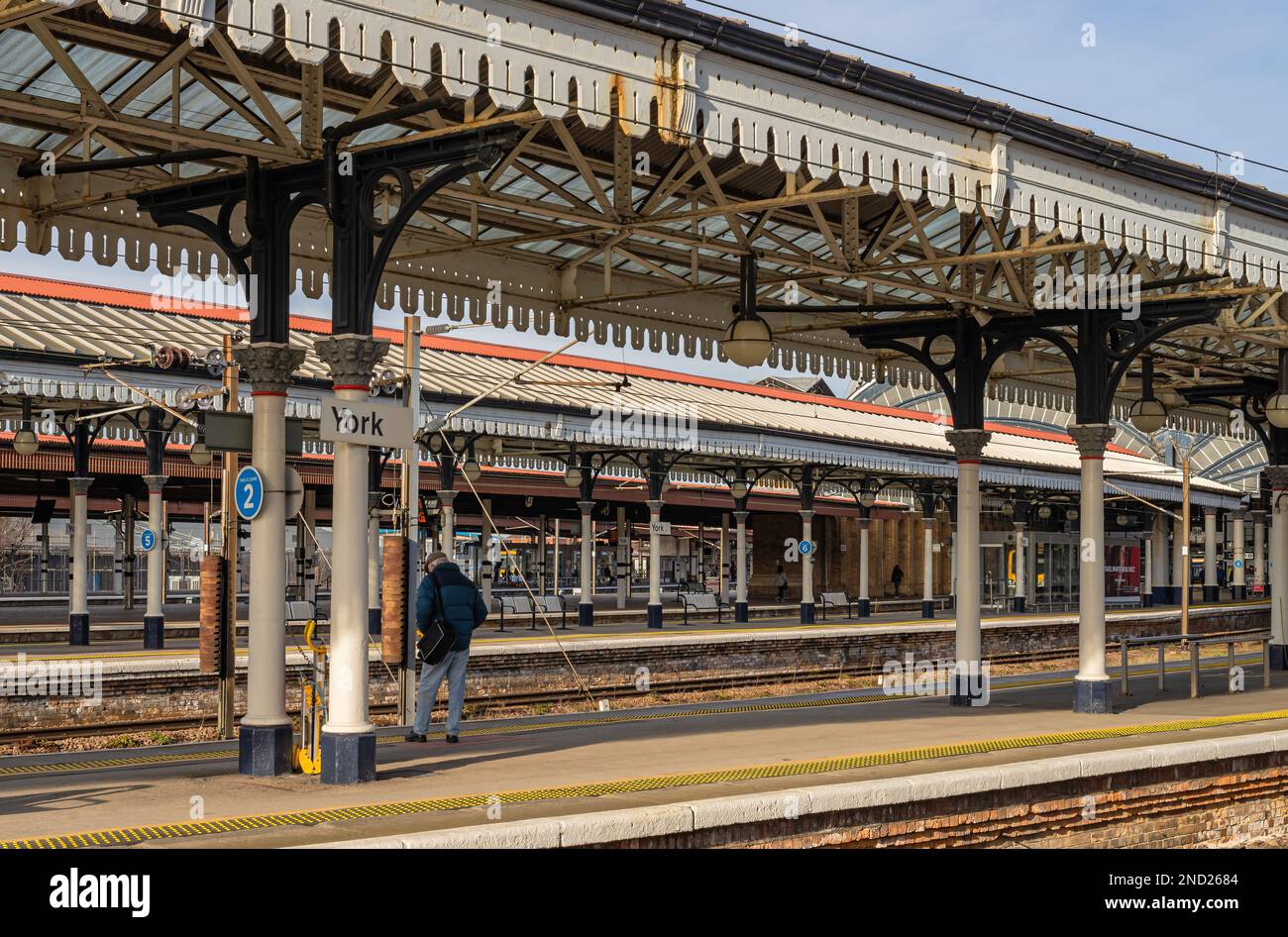 A view of a railway station with a passenger waiting for a train. The ...