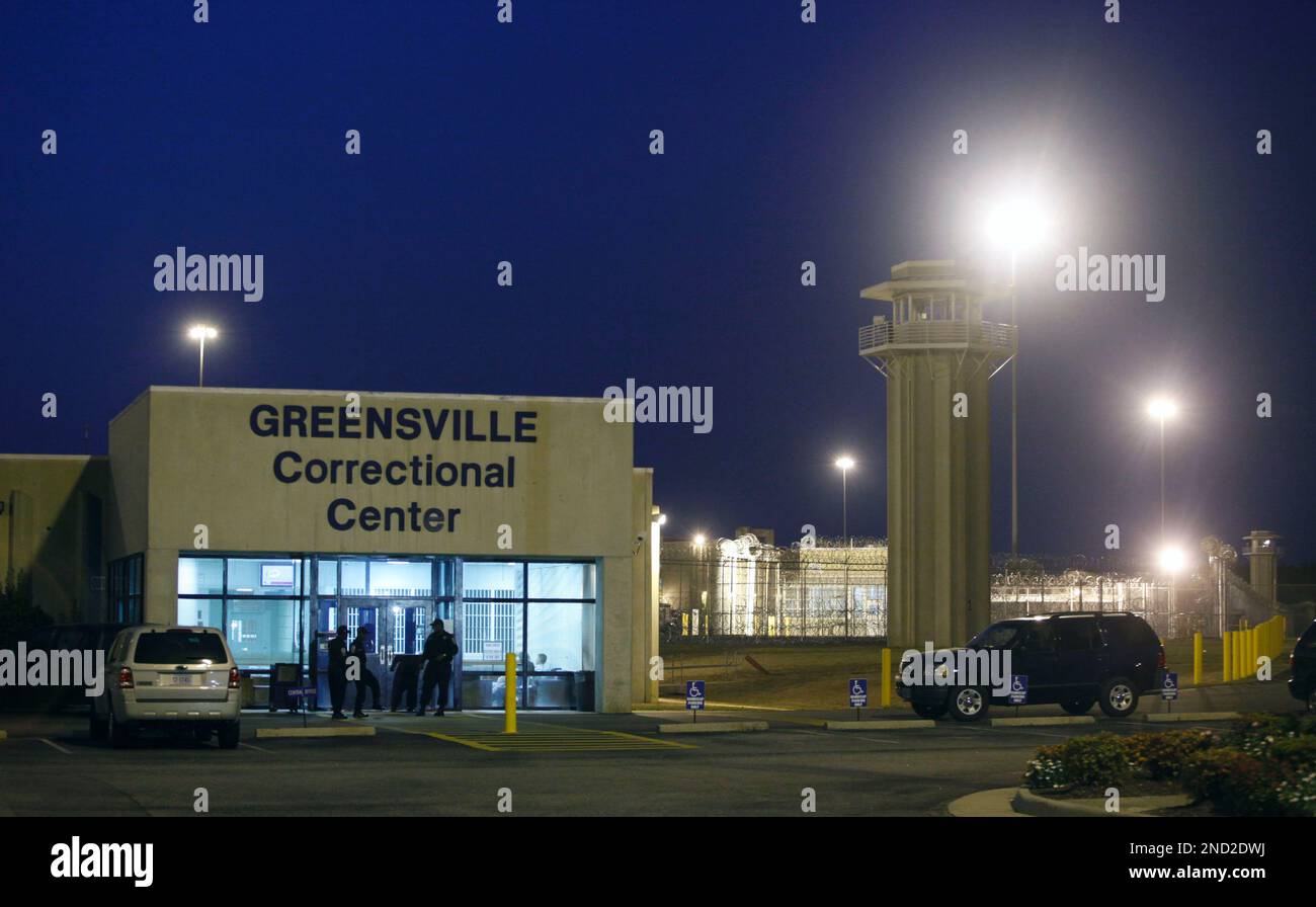 Prison guards mill outside the entrance to the Greensville Correctional