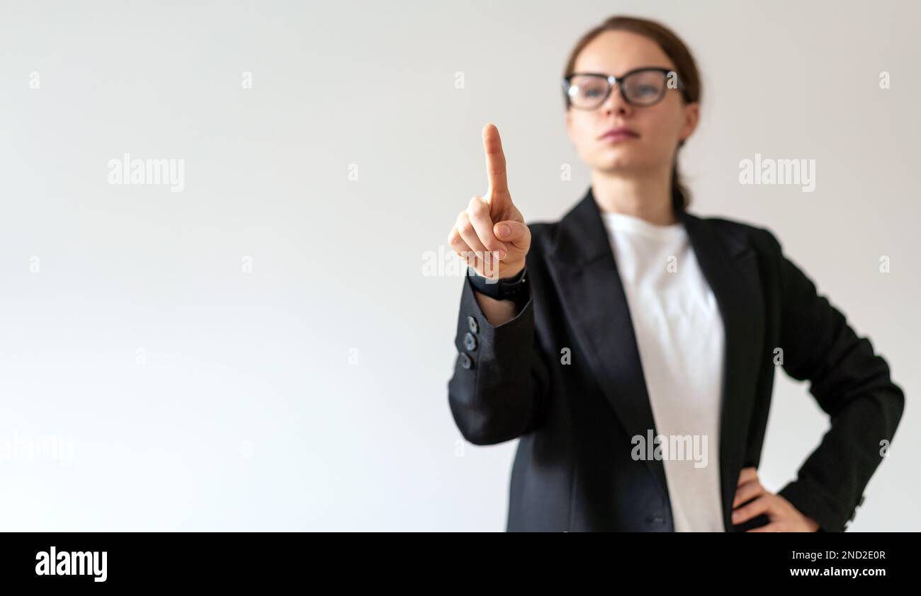 Defocused woman in glasses touching virtual interface, infographic, screen with finger. Stock Photo