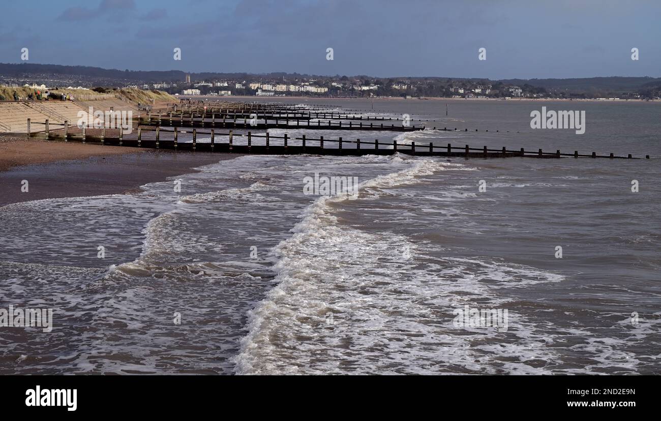 tide and groynes on Dawlish Warren beach, looking towards distant