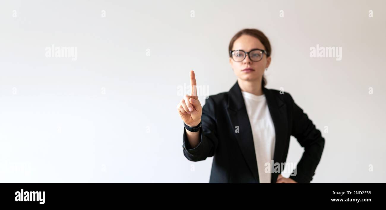 Female business person in background touching virtual interface with her hand. Stock Photo