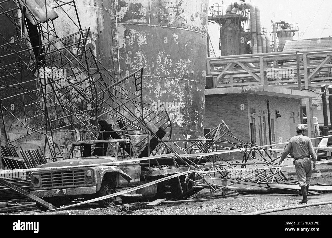 Twisted scaffolding is wrapped around a burnedout truck at the Shell