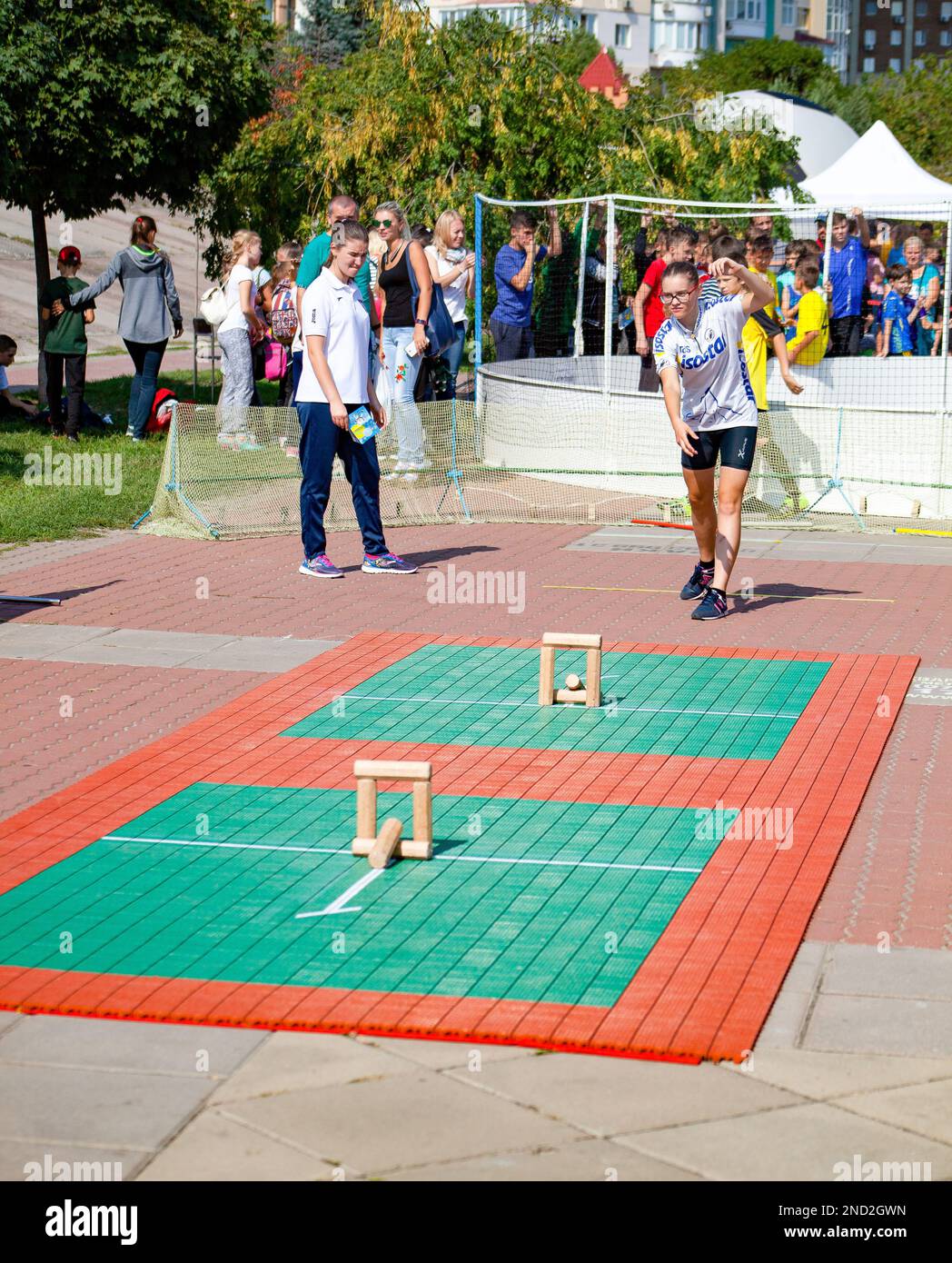 People play the game gorodki. Wooden chocks need to be knocked down with a stick. Aim of game is to knock out groups of skittles by throwing a bat at them. Sport game concept. Kyiv, Ukraine - August 1, 2019 Stock Photo