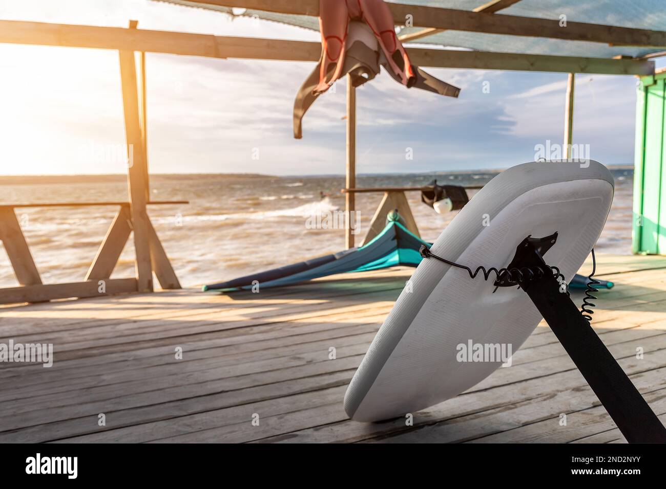 Closeup hydrofoil surf board kite equipment on wooden pier jetty shore