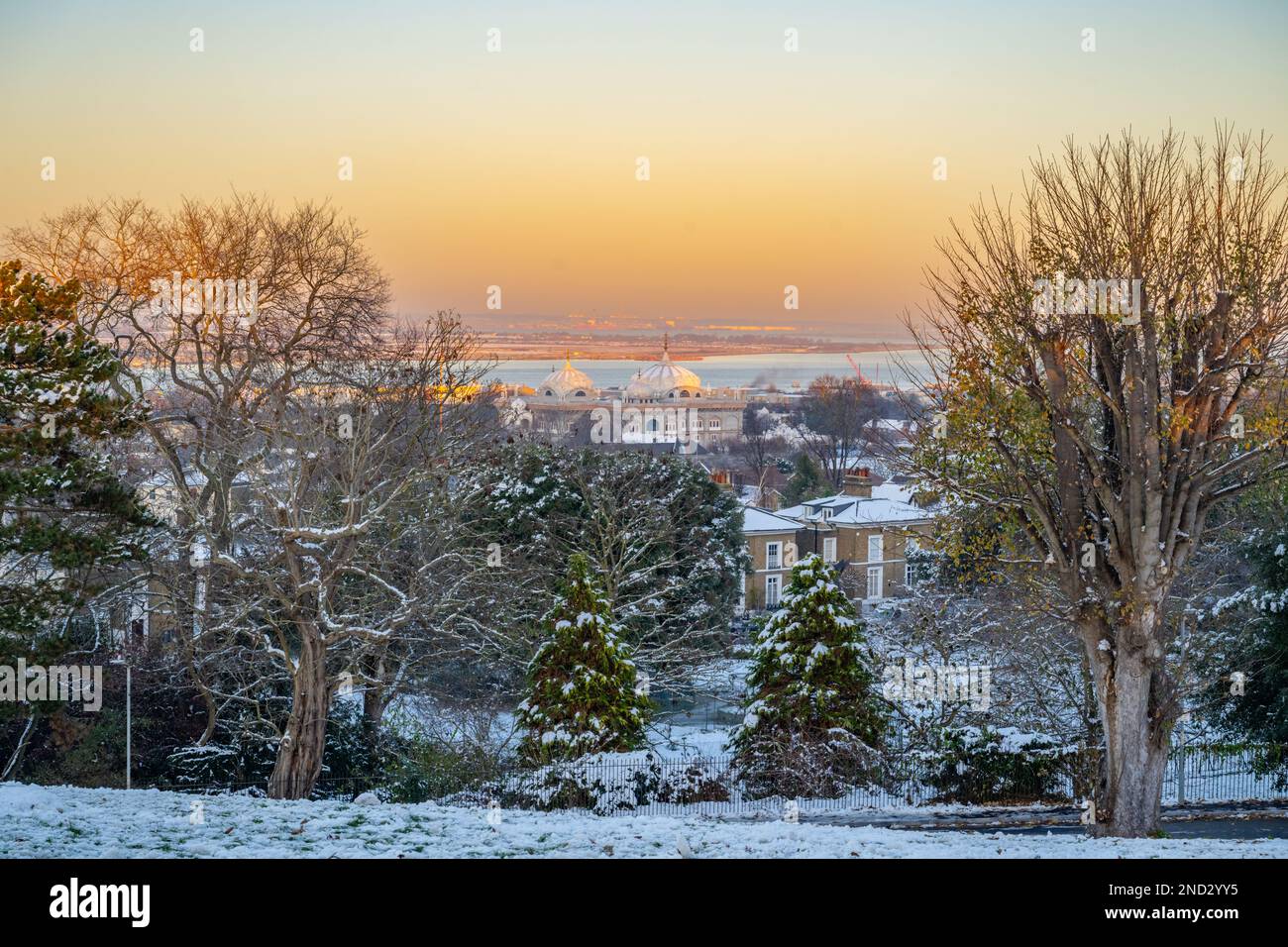Looking towards Thames gateway port in a snowy sunset from Windmill Hill Gravesend Kent in winter with the domes of Gurdwara in middle Stock Photo