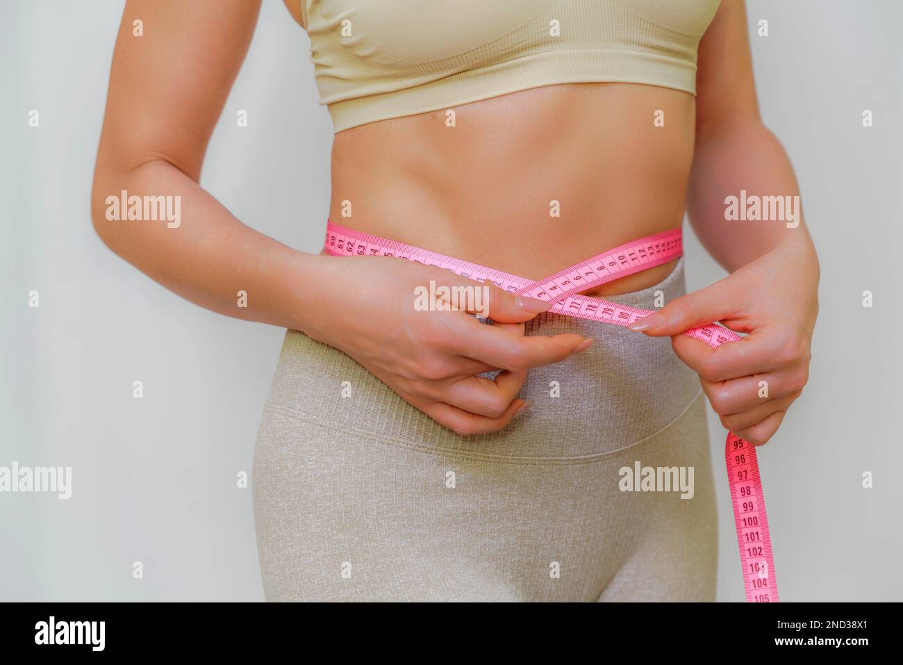 Premium Photo  A slender woman measures her waist with a measuring tape  the concept of weight loss