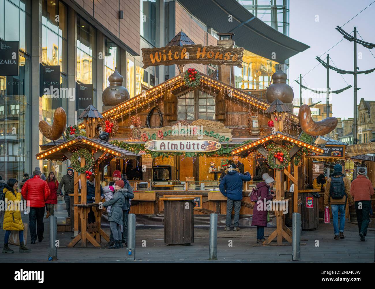 Large wooden chalet style stall selling bratwurst. Manchester Christmas markets. UK Stock Photo