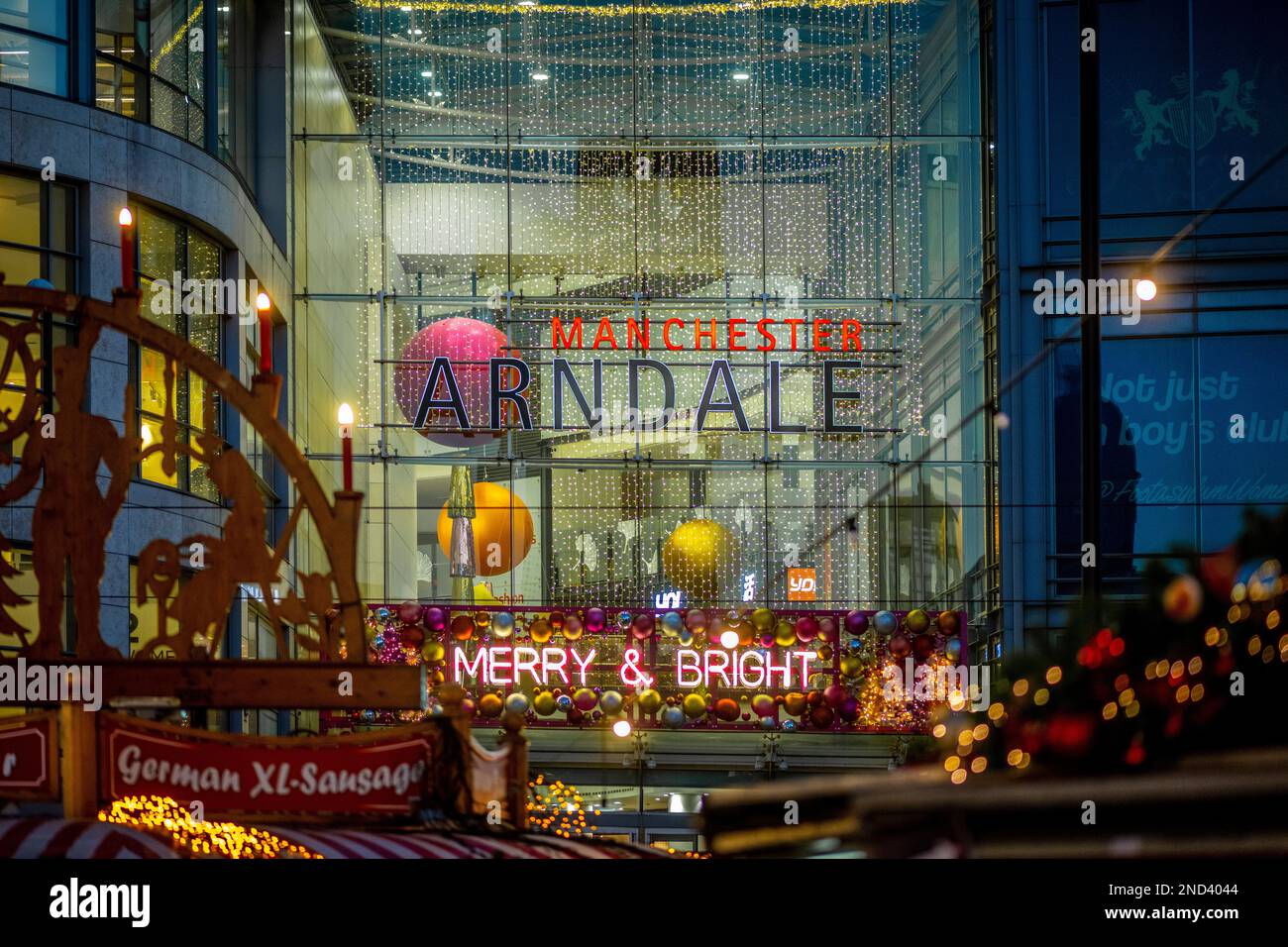 Christmas lights at the Manchester Arndale shopping centre entrance at night. Seen from Christmas markets located in Cathedral Gardens. Manchester. UK Stock Photo