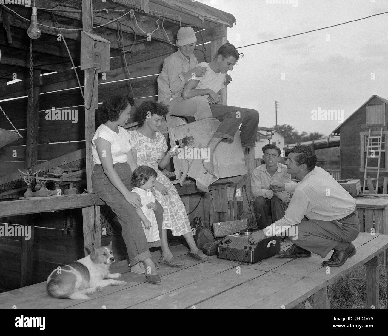 Frank Goldman Kneeling At The Recorder On The Platform Of A Fish Shed frank-goldman-kneeling-at-the-recorder-on-the-platform-of-a-fish-shed