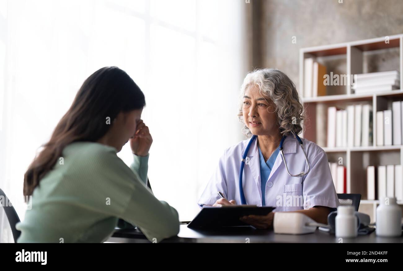 Woman senior doctor is Reading Medical History of Female Patient and ...