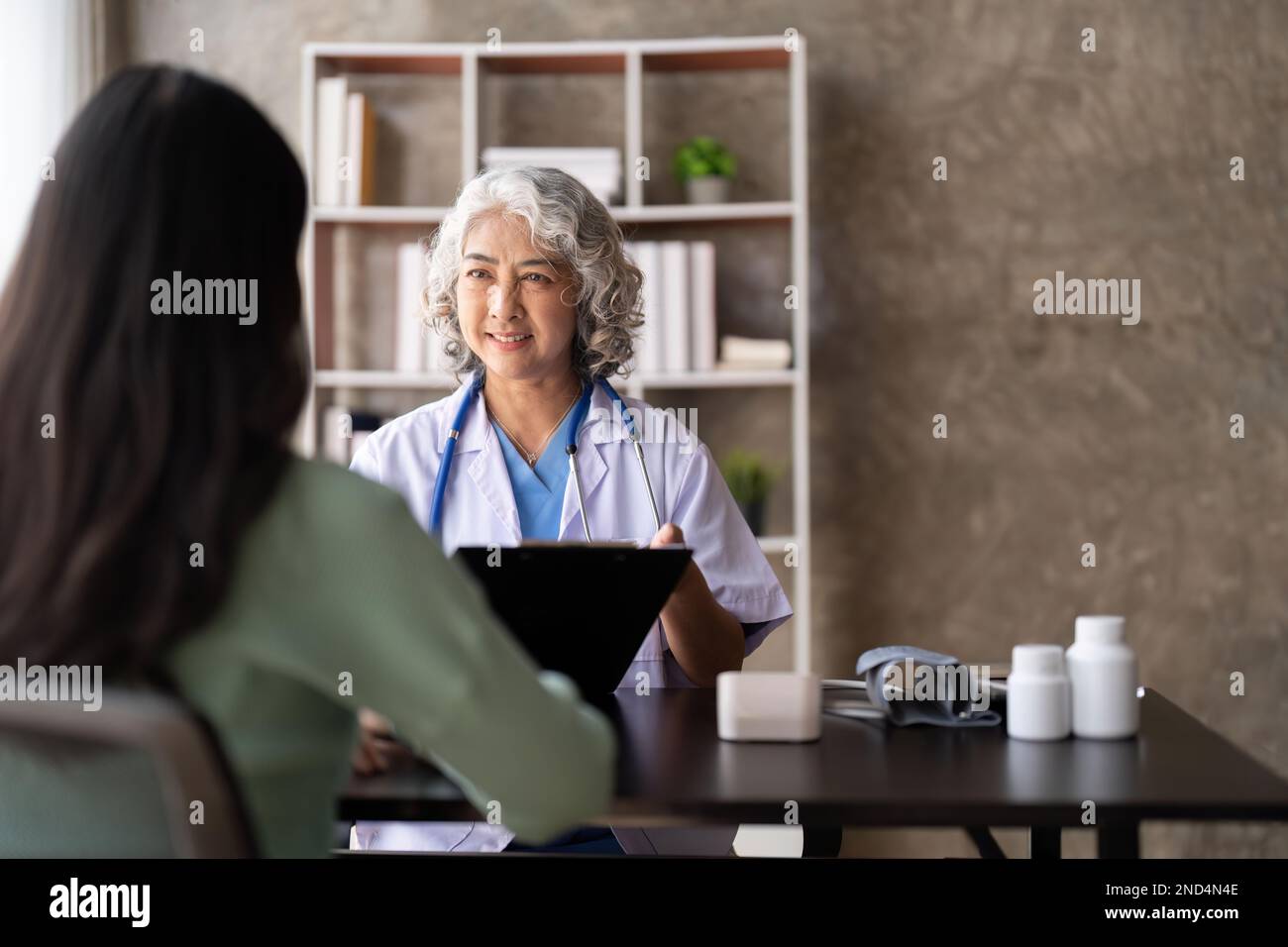 Woman senior doctor is Reading Medical History of Female Patient and ...