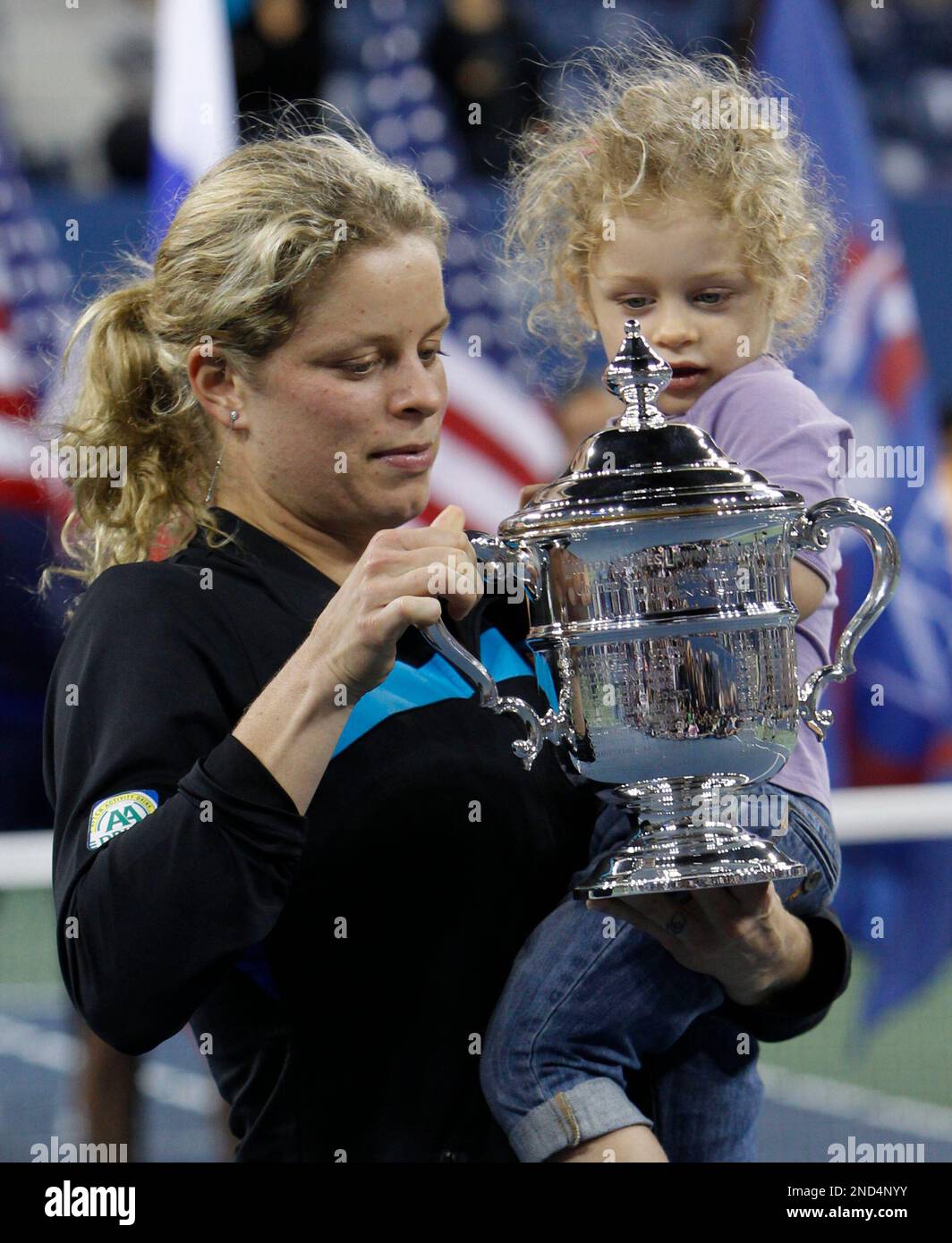 Kim Clijsters, of Belgium, holds the championship trophy and her