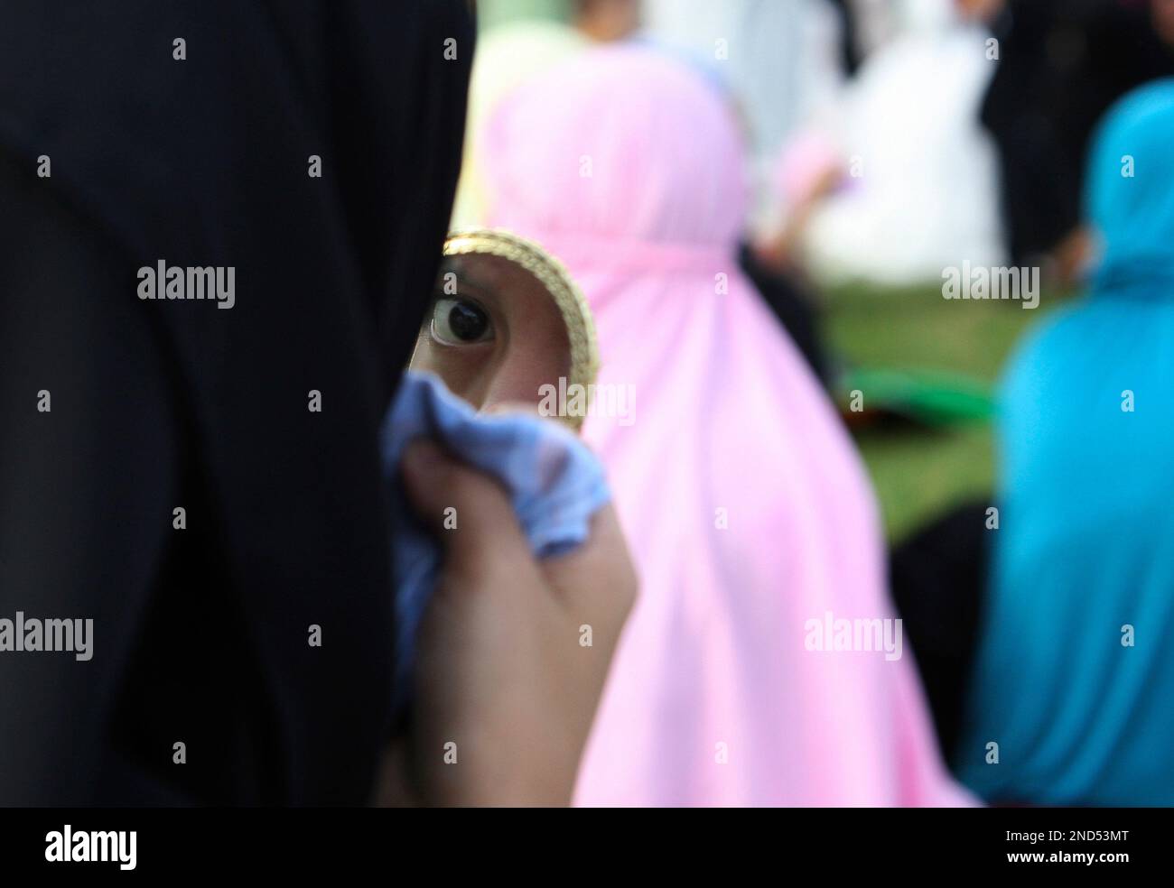 A Filipino Muslim woman checks her makeup as she attends a prayer at