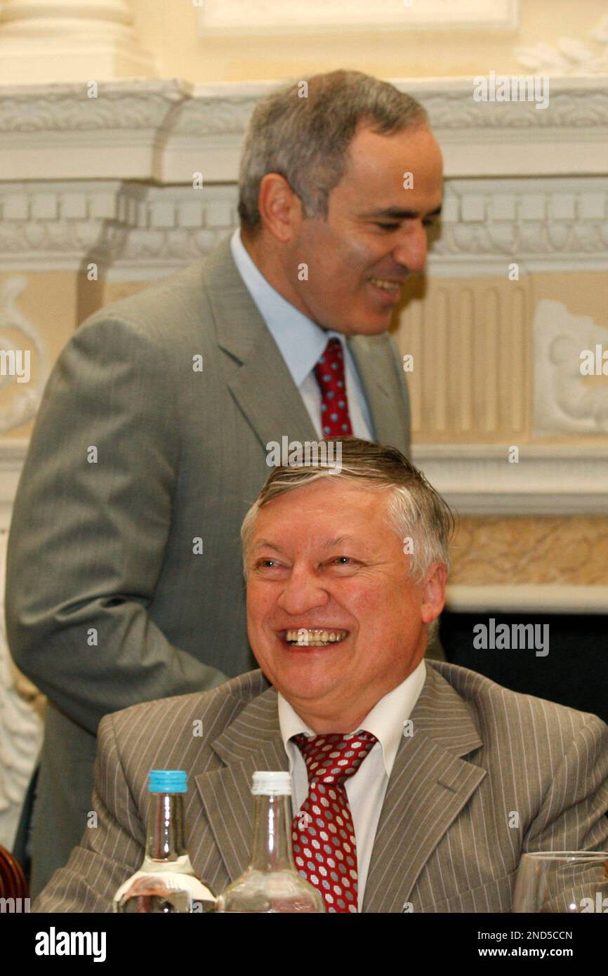 FIDE presidential candidate and former World Chess Champion, Anatoly Karpov, lower, reacts as former World Chess Champion, Garry Kasparov walks pass before the start of their World Chess Federation (FIDE) presidential election
