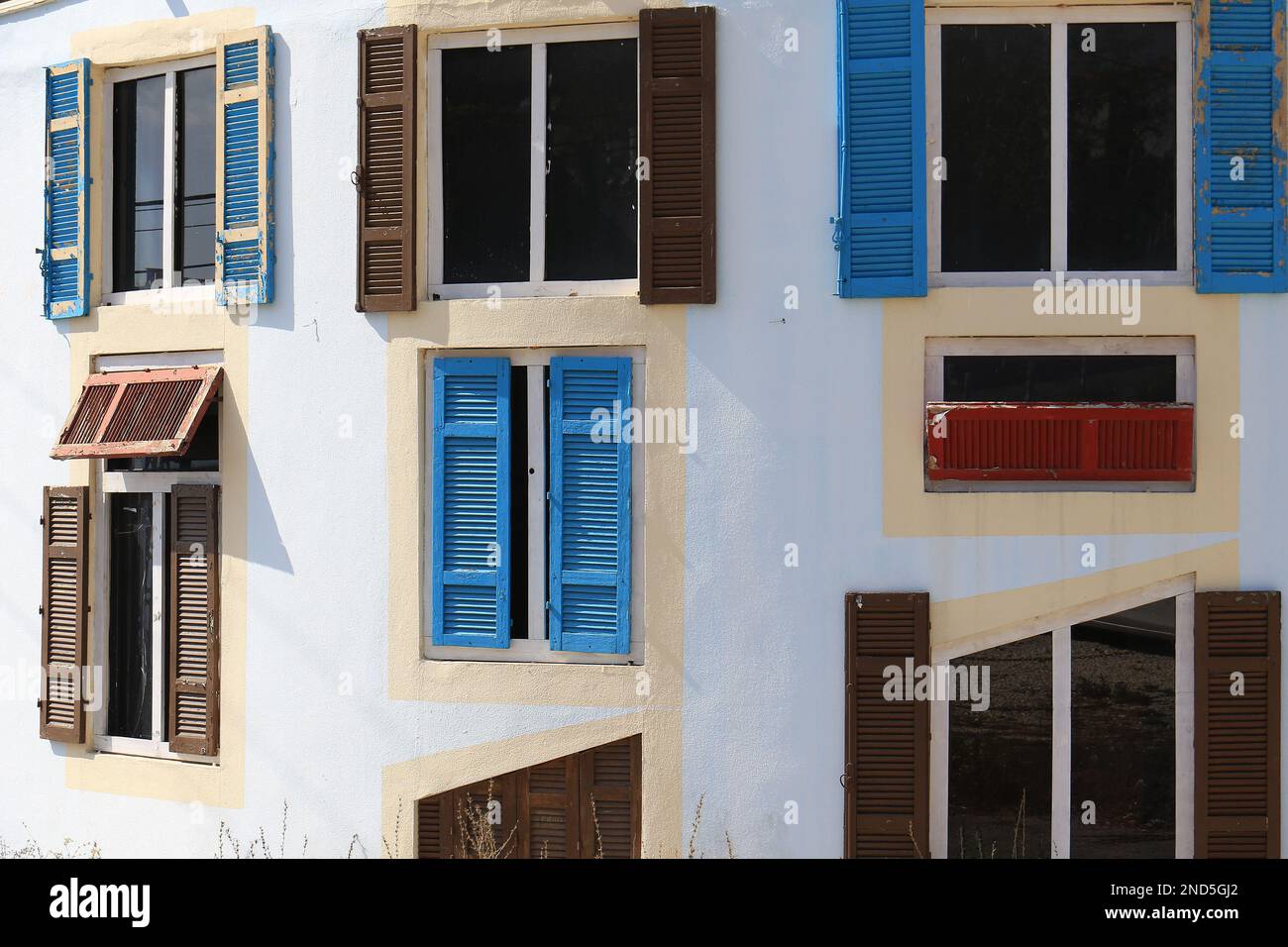 Facade of a building with multiple windows. with different colors and shapes. Stock Photo