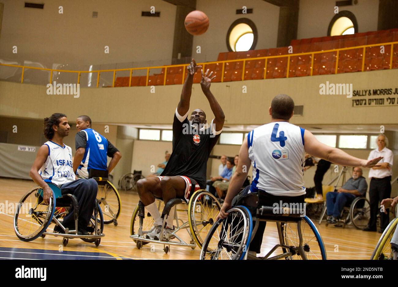 Former NBA basketball player Anthony Bonner, center, plays against members  of the national Israeli handicapped basketball team during a game to raise  awareness about disabilities and encourage support for the Paralympic Games