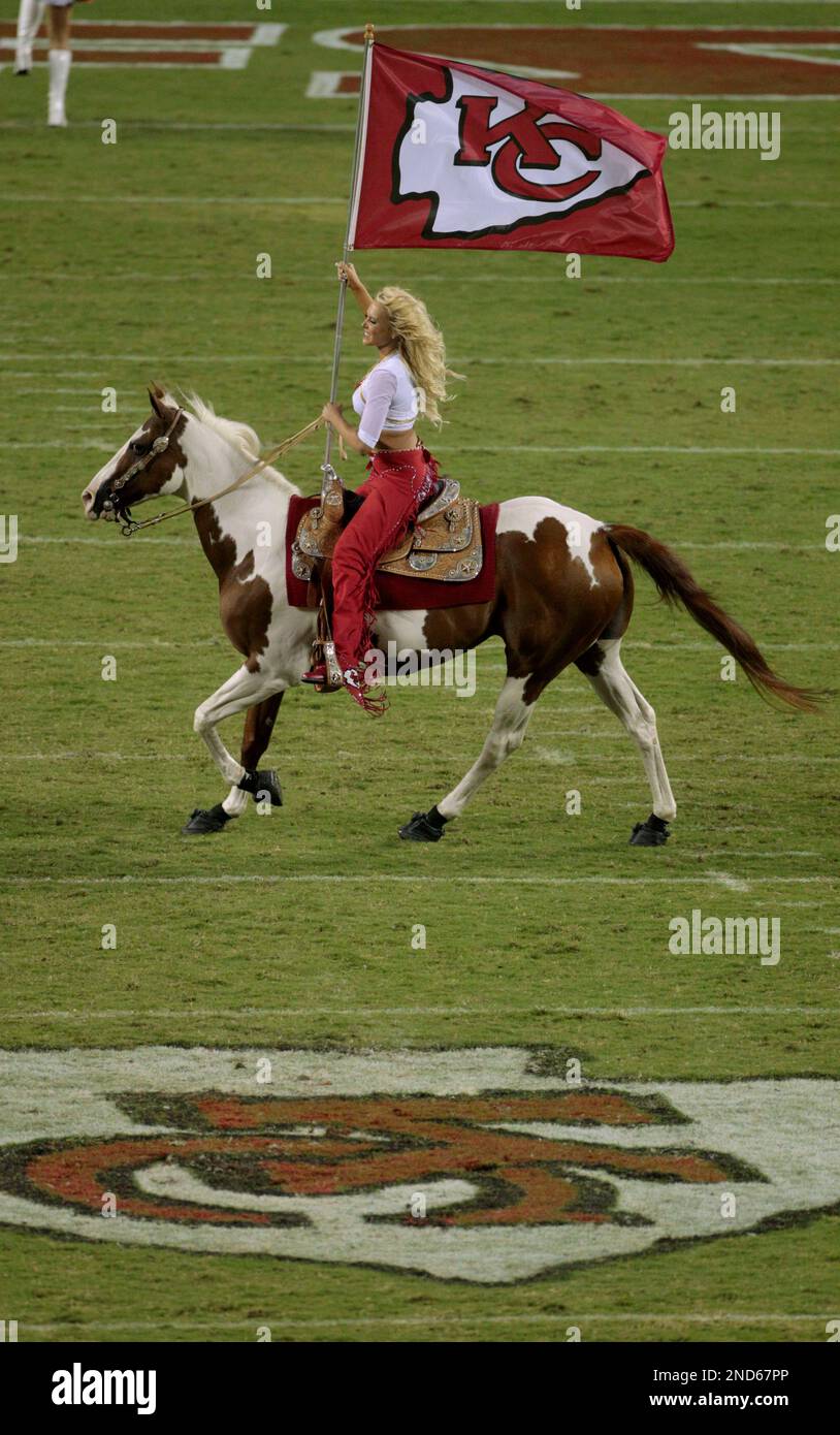 A Kansas City Chiefs cheerleader rides Chiefs mascot Warpaint after a