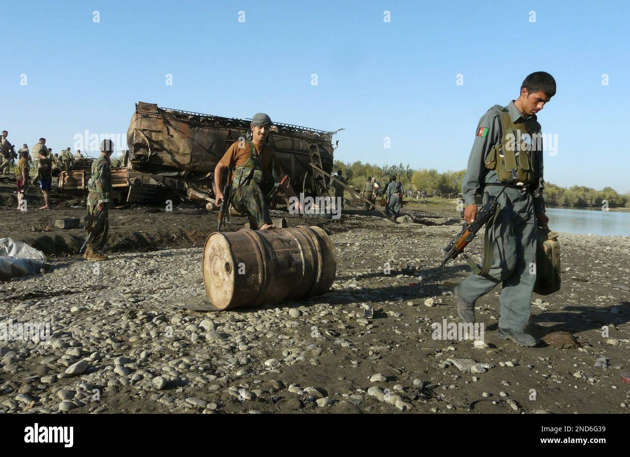 ARCHIV - Afghanische Soldaten rollen am 5. September 2009 vor einem  explodierten Tanklaster in Kundus eine Tonne. Vor gut einem Jahr sind bei  dem dem Bombardement zweier entfuehrter Tanklastzuege am 4. September