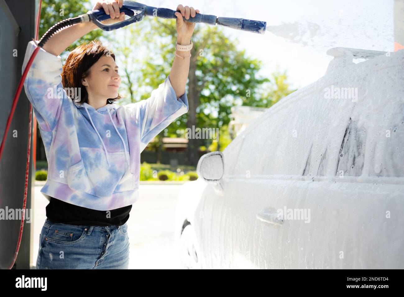 Girl washing a car in a selfservice car wash station Stock Photo Alamy