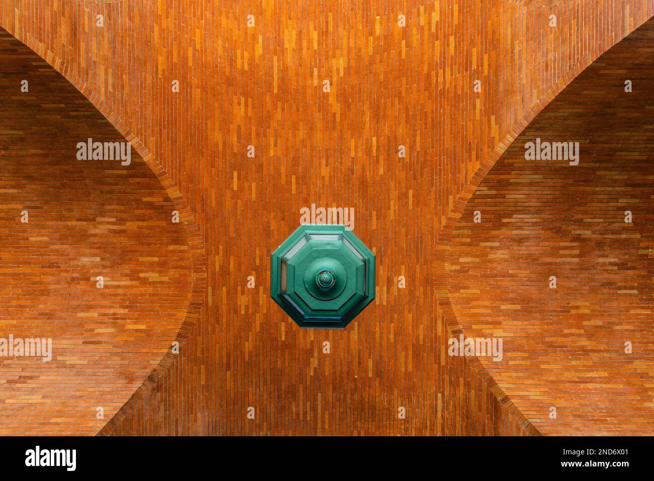 Low angle view of brick vault and green lamp. Directly below view Stock Photo