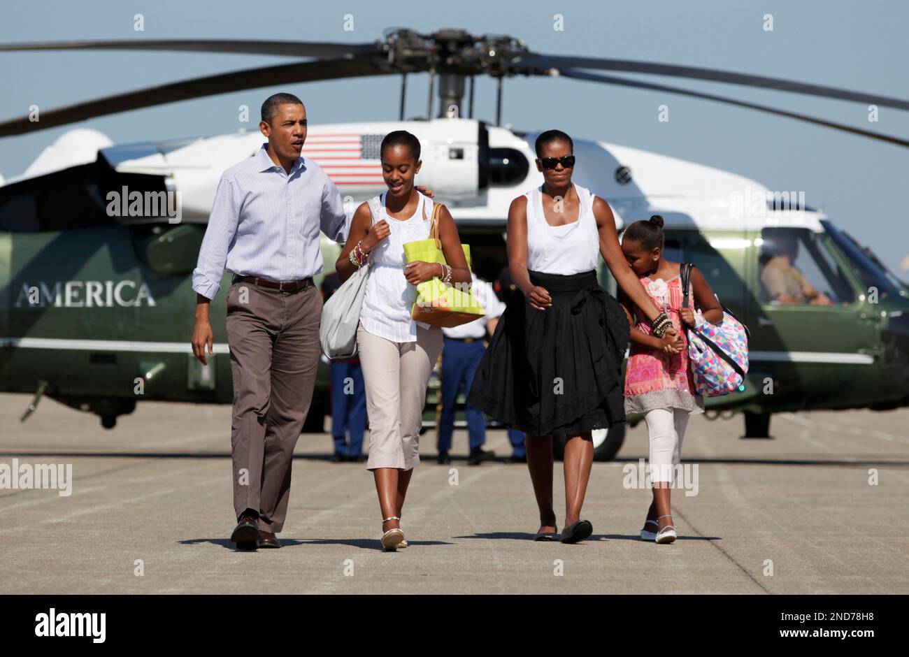 President Barack Obama walks with daughter Malia and first lady