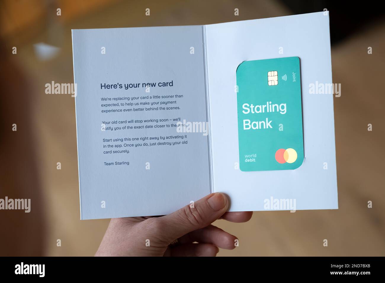 A Starling bank customer holds a just delivered new debit card. Starling are a digital challenger cashless bank based in the UK Stock Photo
