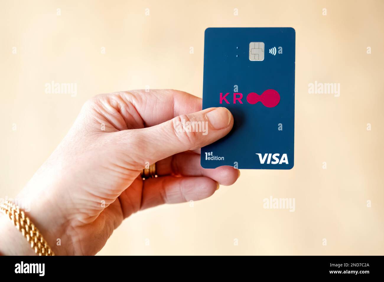 A Kroo Bank visa debit card being held by a customer. Kroo are a UK based digital Challenger bank which operates a high interest cashless  service. Stock Photo