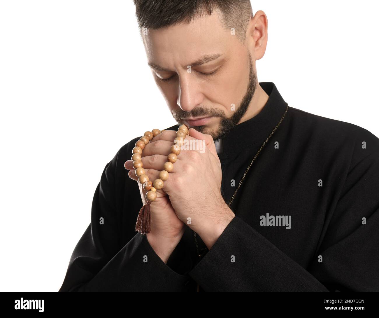 Priest with beads praying on white background Stock Photo
