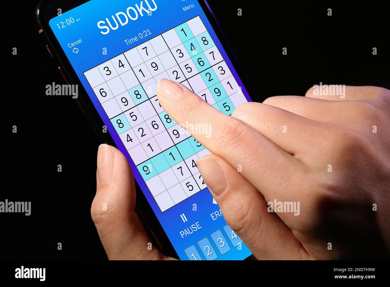 Woman playing sudoku game on smartphone, closeup Stock Photo
