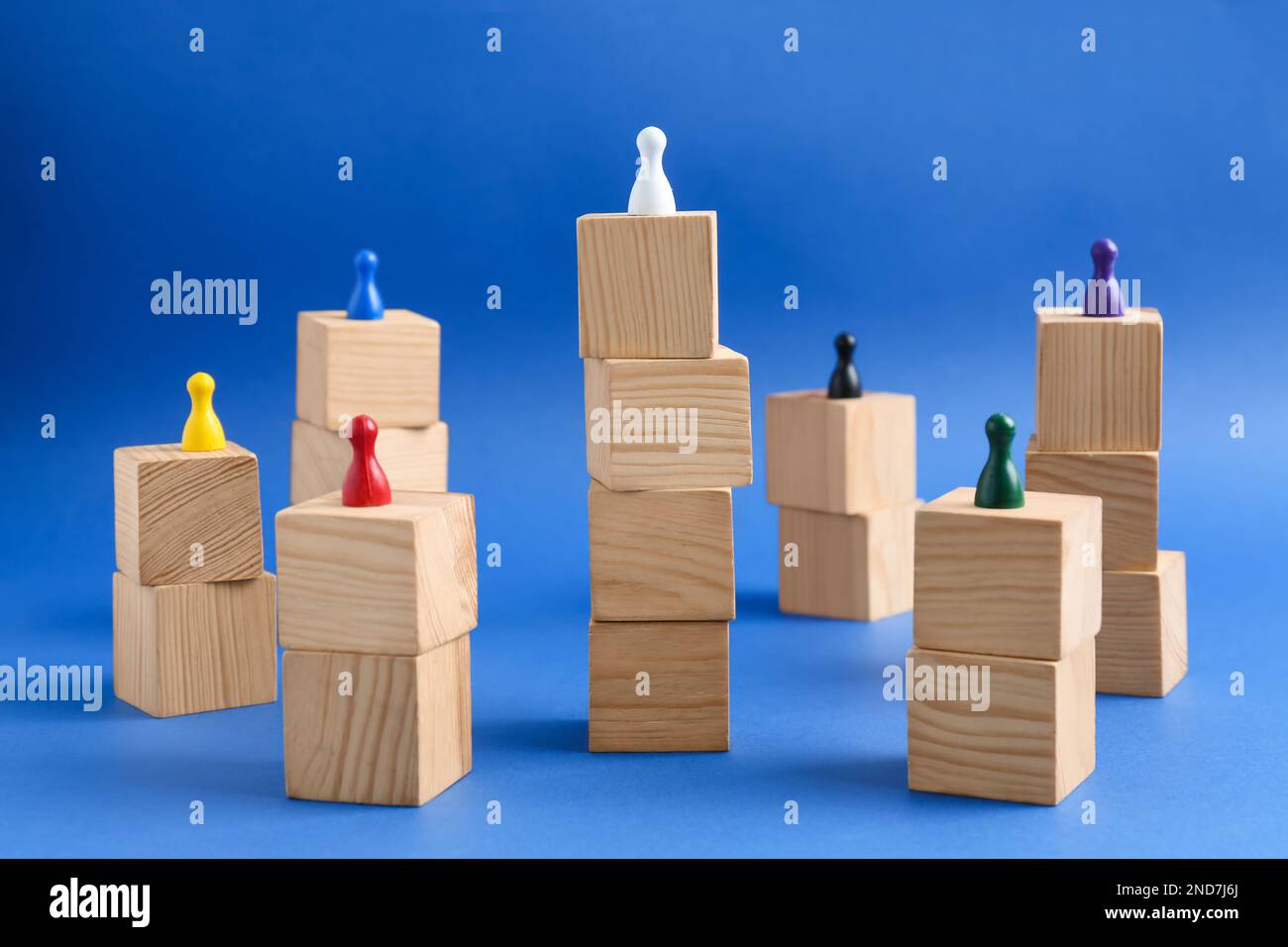 Wooden blocks with color playing pieces on blue background. Roles and responsibility concept Stock Photo