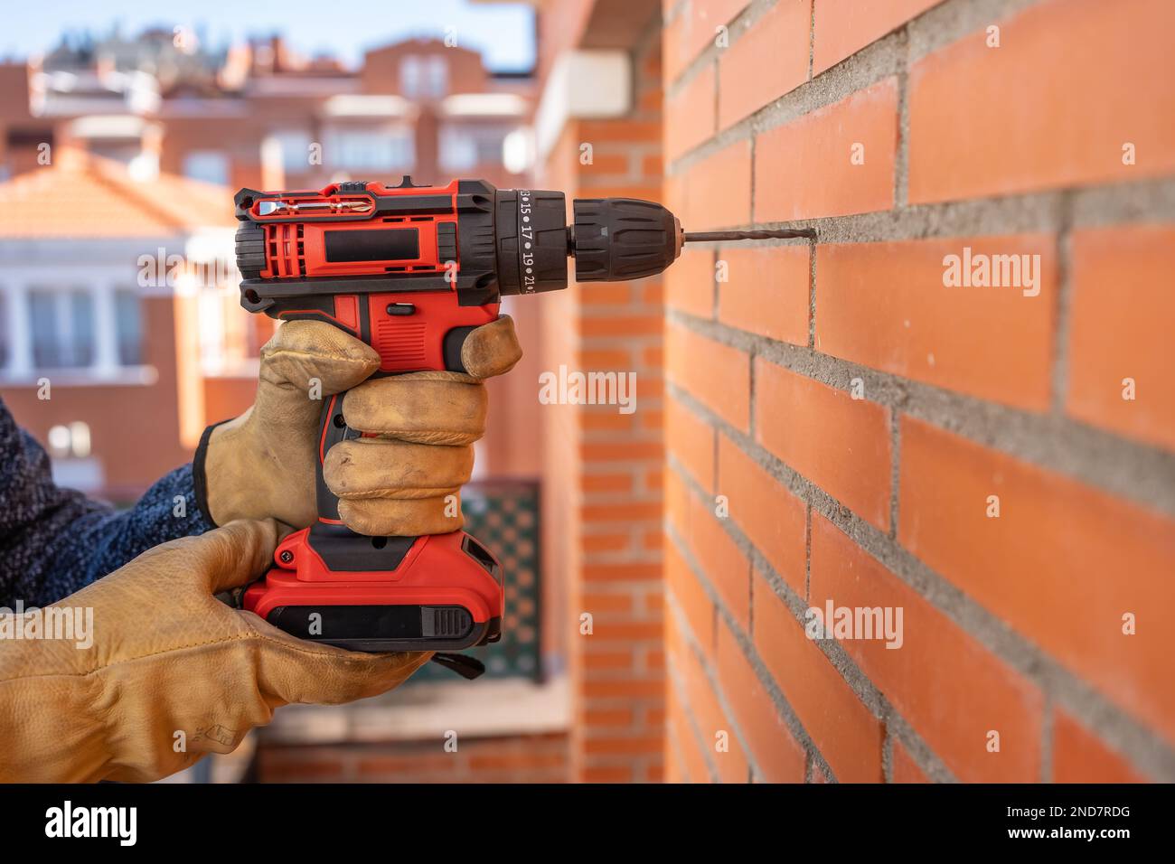 Drilling machine with battery making holes in a brick wall outside Stock Photo Alamy