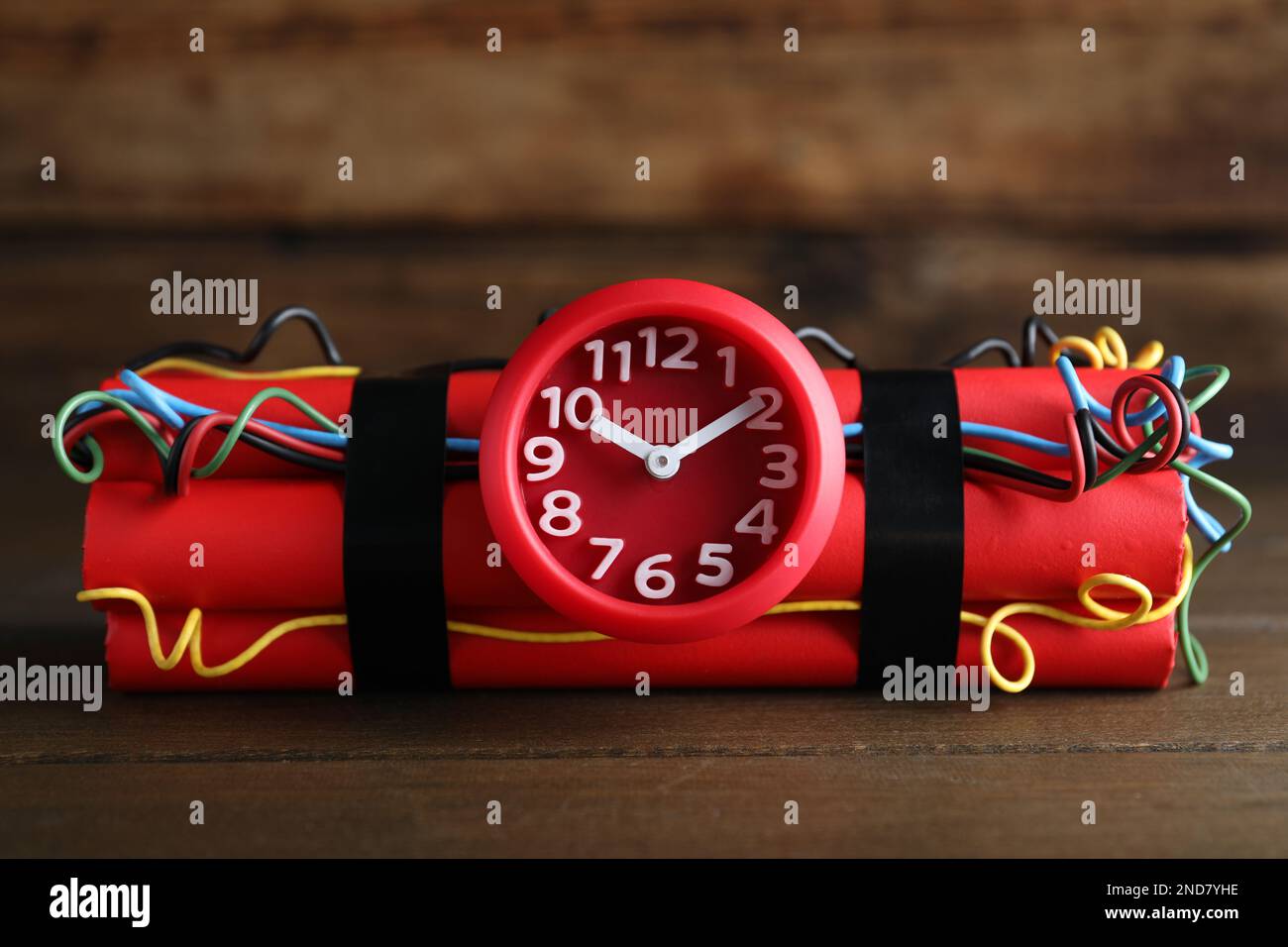 Dynamite time bomb on wooden table, closeup Stock Photo