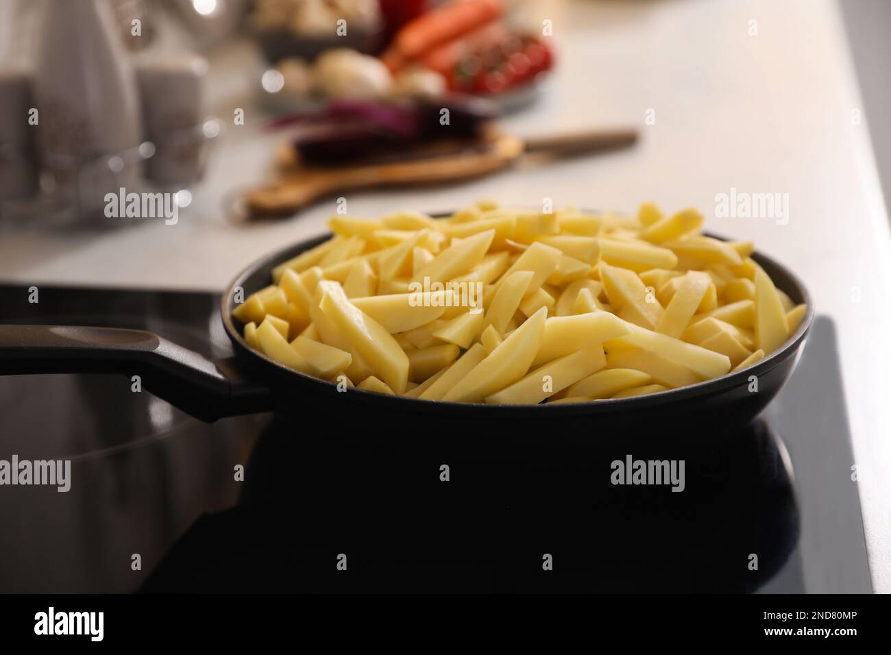 Frying pan with cut raw potatoes on cooktop Stock Photo - Alamy