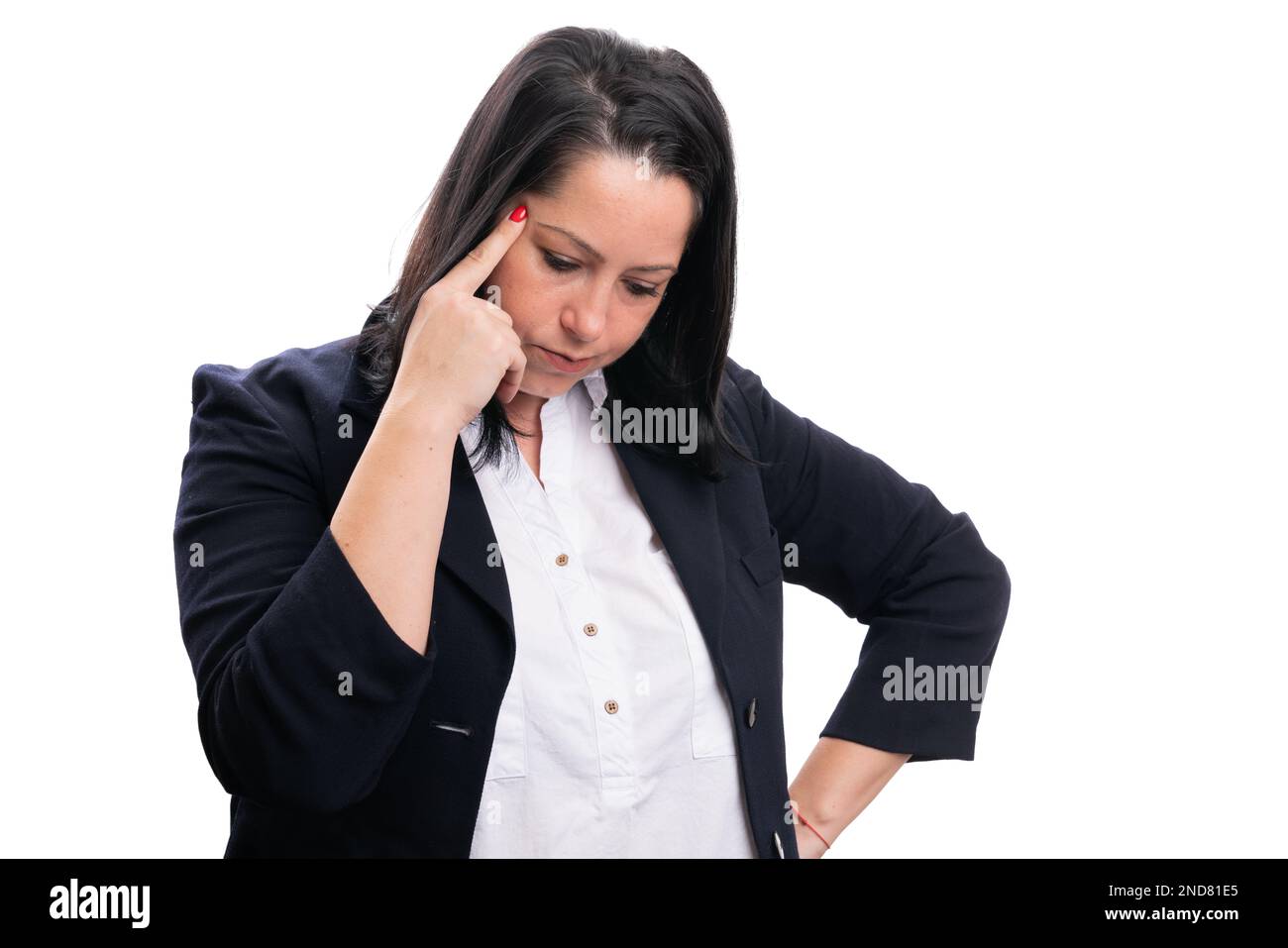Focused adult female entrepreneur in smart casual clothing thinking while touching temple with index finger isolated on white studio background Stock Photo