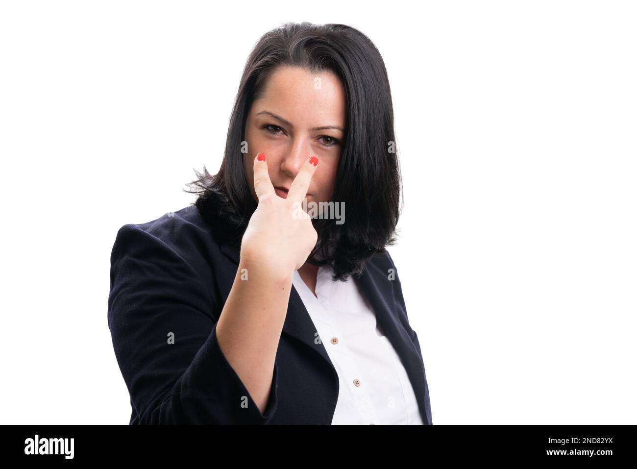 Adult businesswoman wearing formal suit with serious expression making eyes on you gesture using fingers as corporate supervisor concept isolated on w Stock Photo
