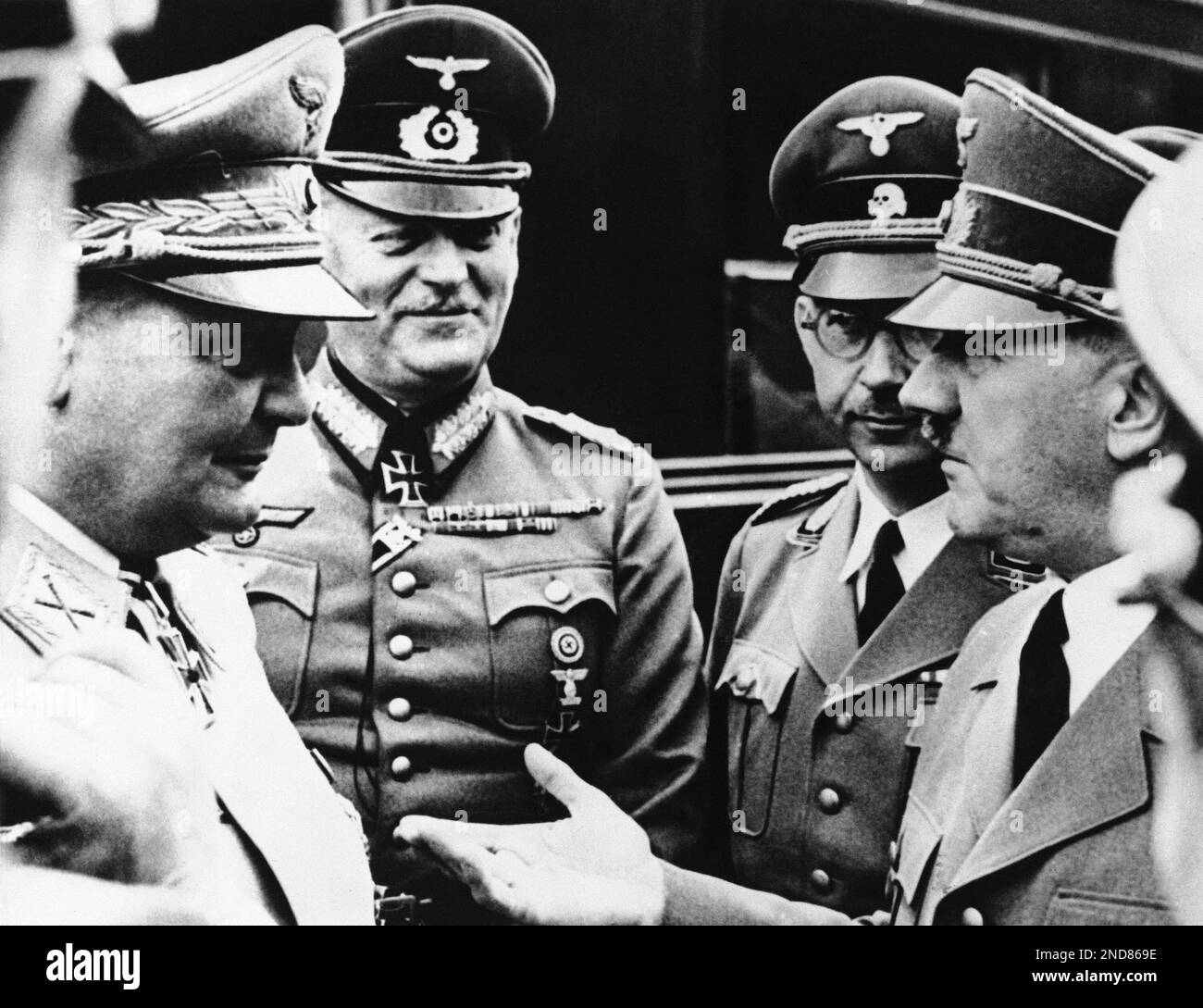 Gesturing with an outstretched hand, Adolf Hitler, right, at Hitler’s