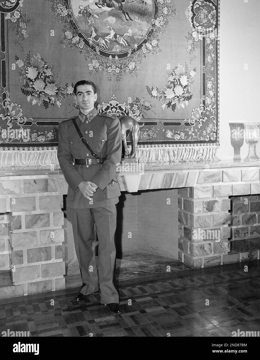 Mohammed Reza Shah Pahlavi, King of Iran, stands at the mantle of his study in Tehran April 30, 1946. He is wearing the uniform of the Iranian Army. The 27-year-old ruler of Iran’s 15,000,000 people became “King of Kings” in 1941 after the exile of his father, the late Riza Shah. (AP Photo/Tom Fitzsimmons) Stock Photo