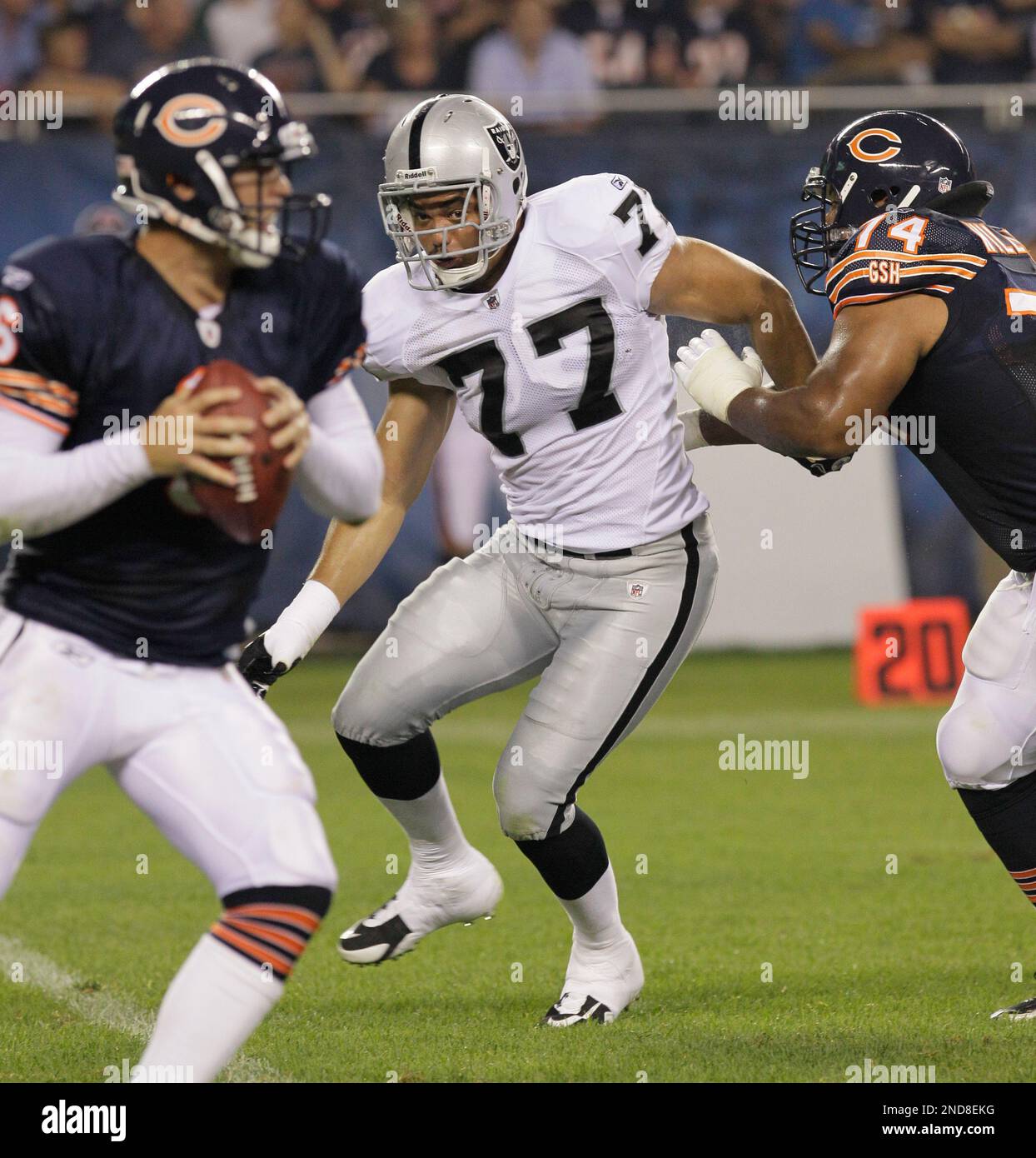 Oakland Raiders defensive end Matt Shaughnessy, center, fights off a