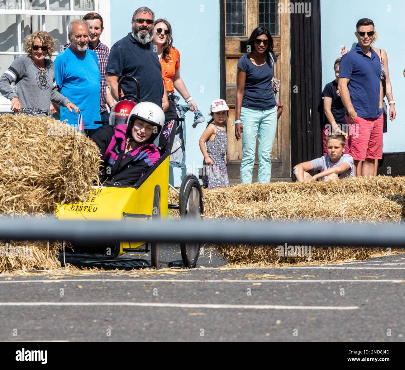 Straw Driver A soapbox has crashed into a straw bale during a race, just visible ...