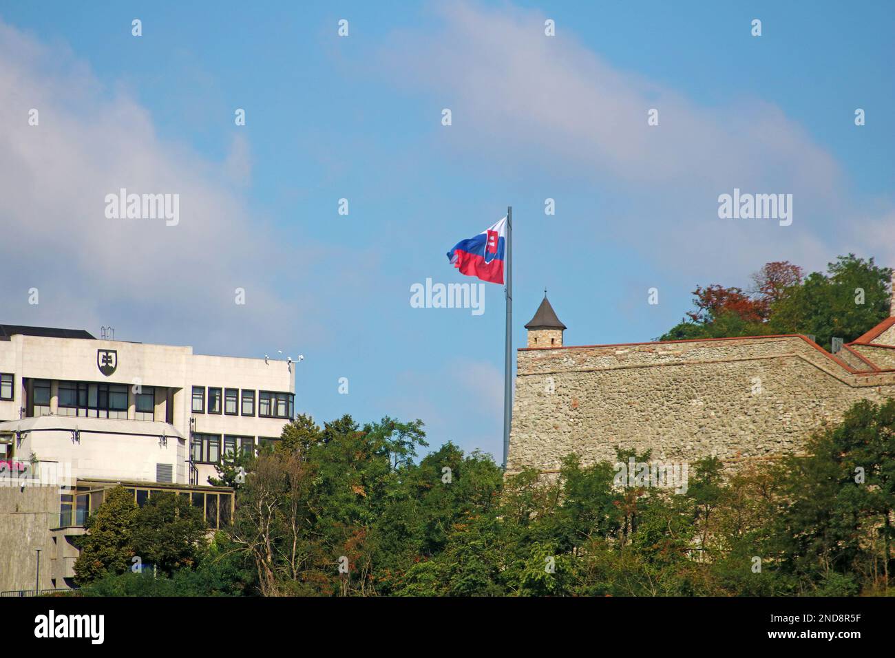 Bratislava, Slovakia - September 03, 2019: Slovak National Parliament and slovak flag, part of old wall of Bratislava castle Stock Photo