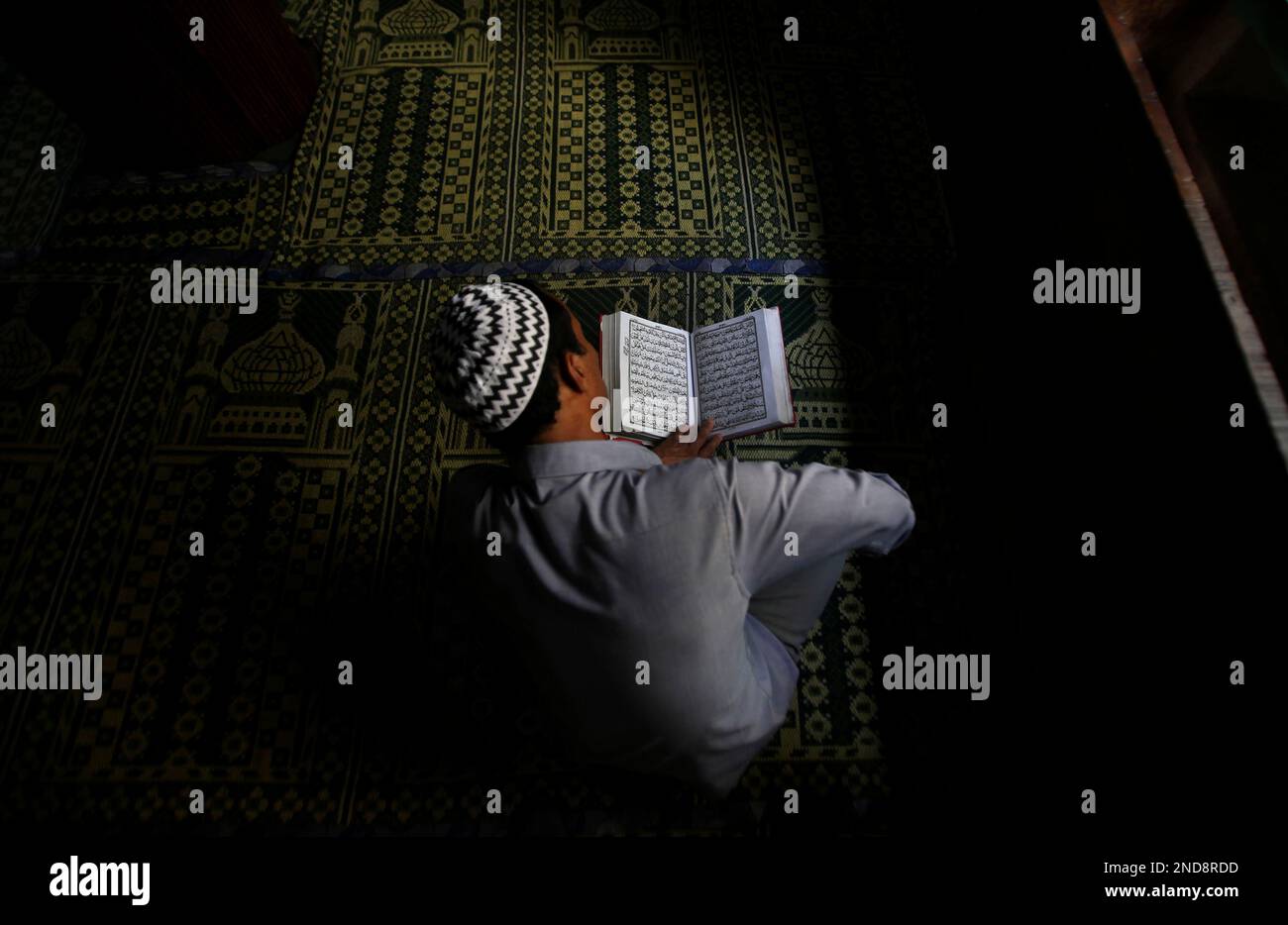A Kashmiri Muslim reads the Holy Quran inside a shrine in Srinagar ...