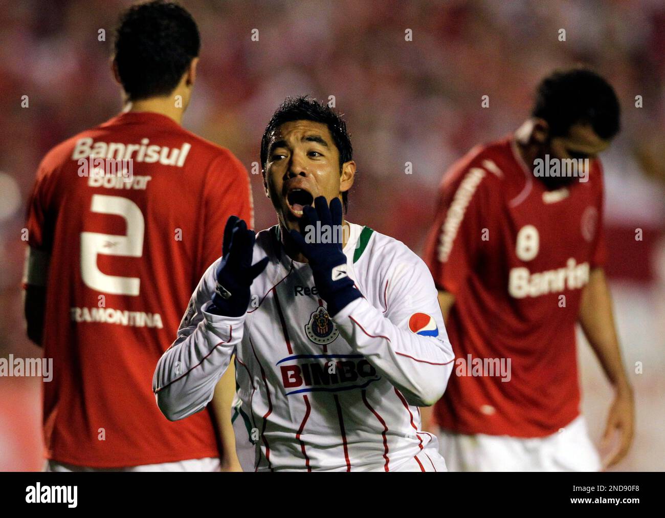 Mexico Chivas' Marco Fabian, front, celebrates after scoring during the Copa Libertadores final soccer match against Brazil's SC Internacional in Porto Alegre, Brazil, Wednesday, Aug. 18, 2010. At left, Brazil's SC Internacional's Bolivar. (AP Photo/Silvia Izquierdo) Stock Photo