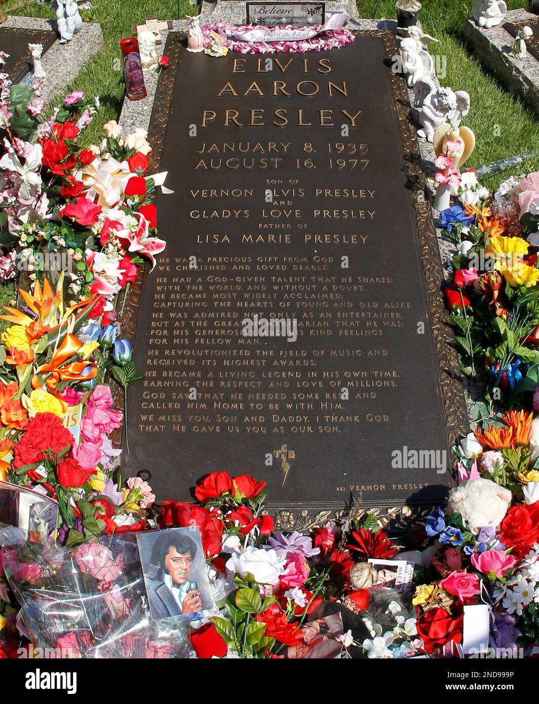 Flowers and tributes left by fans decorate Elvis Presley's grave at  Graceland, his Memphis, Tenn. home, on Monday, Aug. 16, 2010. Elvis Presley  fans from around the world have come to Graceland, image size:1064x1390