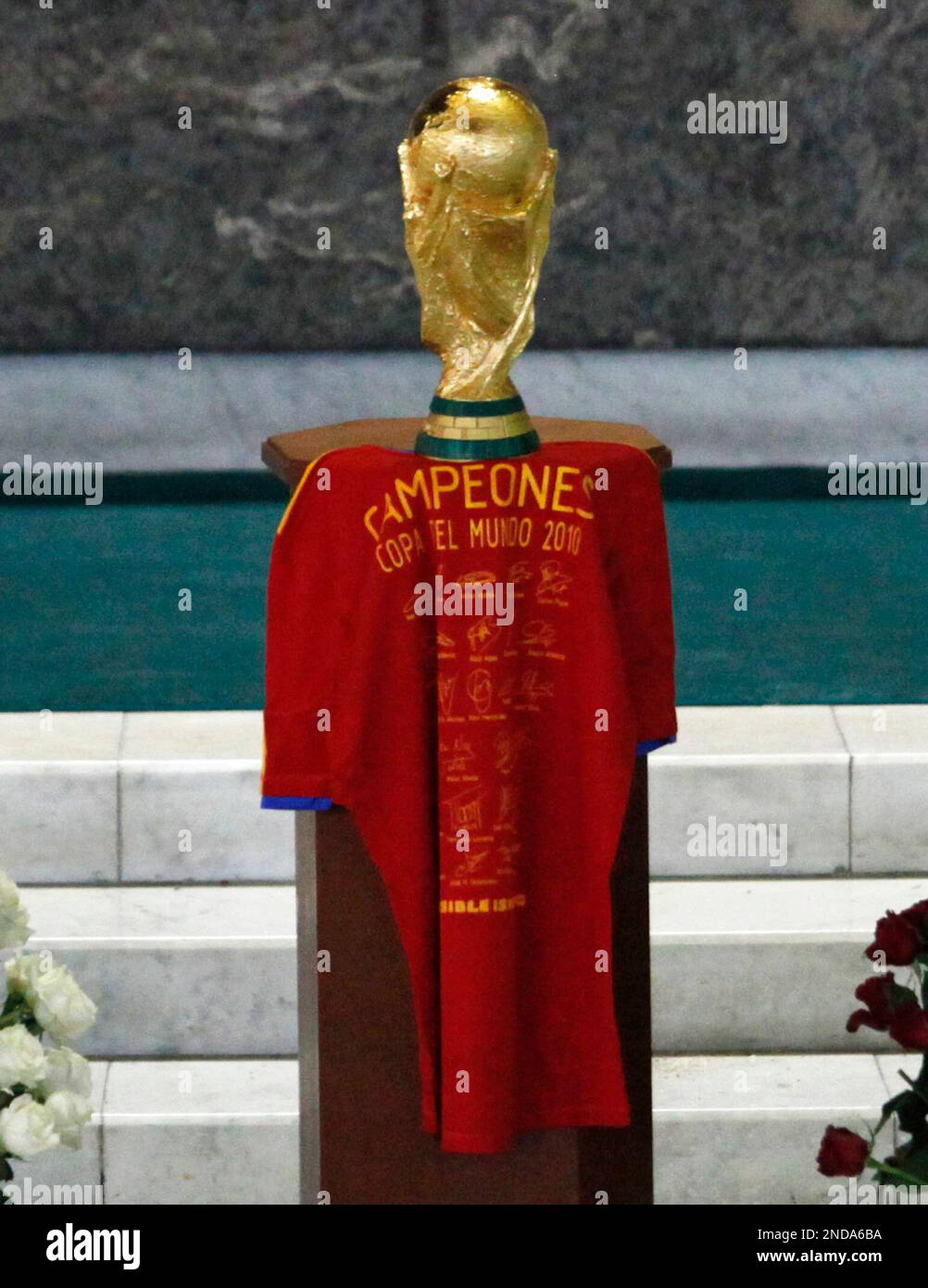 The World Cup trophy sits on a Spanish national soccer team jersey during a mass at the Basilica of Guadalupe in Mexico City, Tuesday, Aug. 10, 2010. Spain will face Mexico in a friendly soccer match on Wednesday, Aug. 11. (AP Photo/Eduardo Verdugo) Stock Photo