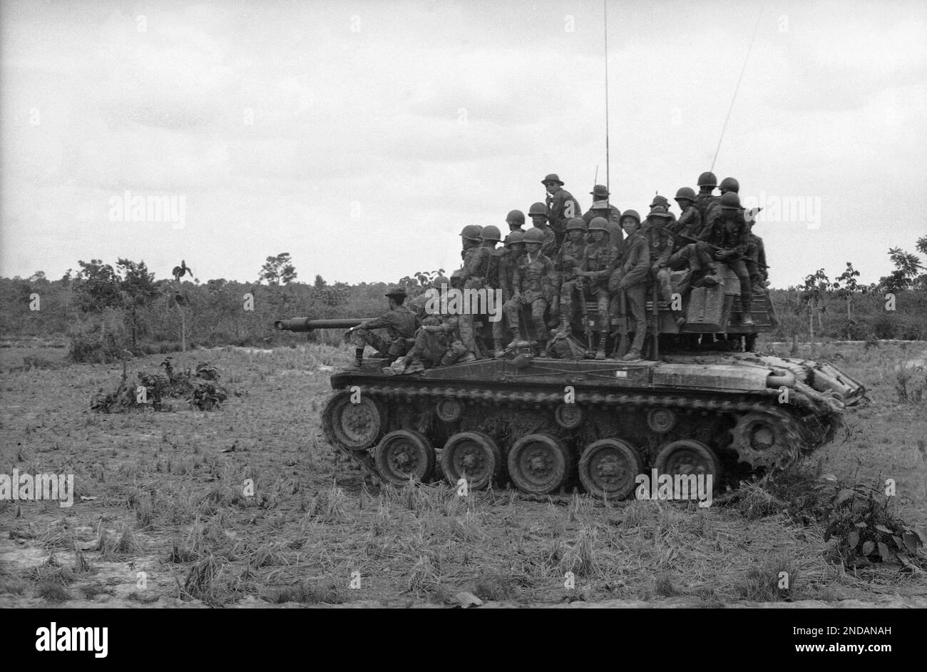 South Vietnamese rangers crowd onto the top of a tank moving through ...